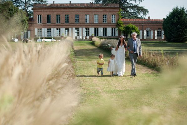 Entree de la mariee au bras de son papa devant le chateau