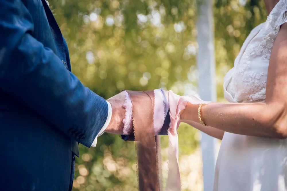 un couple se tient les mains avec des rubans